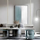 A modern living room with a gray sofa, round coffee tables, glass side table, Giant Sculptures Verta Blue Gradient Acrylic 3D Wall Art, decorative vases, neutral cushions, and a minimalist hanging globe lamp in soft muted tones.