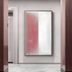 A modern hallway showcases the Giant Sculptures Verta Rose Gradient Acrylic 3D Wall Art, featuring vertical ridges and a rose pink-to-white gradient, mounted on a pale wall between marble floors and polished wooden door frames.