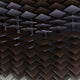 Close-up of a ceiling or wall featuring Giant Sculptures Tessera Caramel & Walnut Gradient Acrylic 3D Wall Art, with dark, shiny panels arranged in a staggered pattern for a striking geometric and modern visual effect.