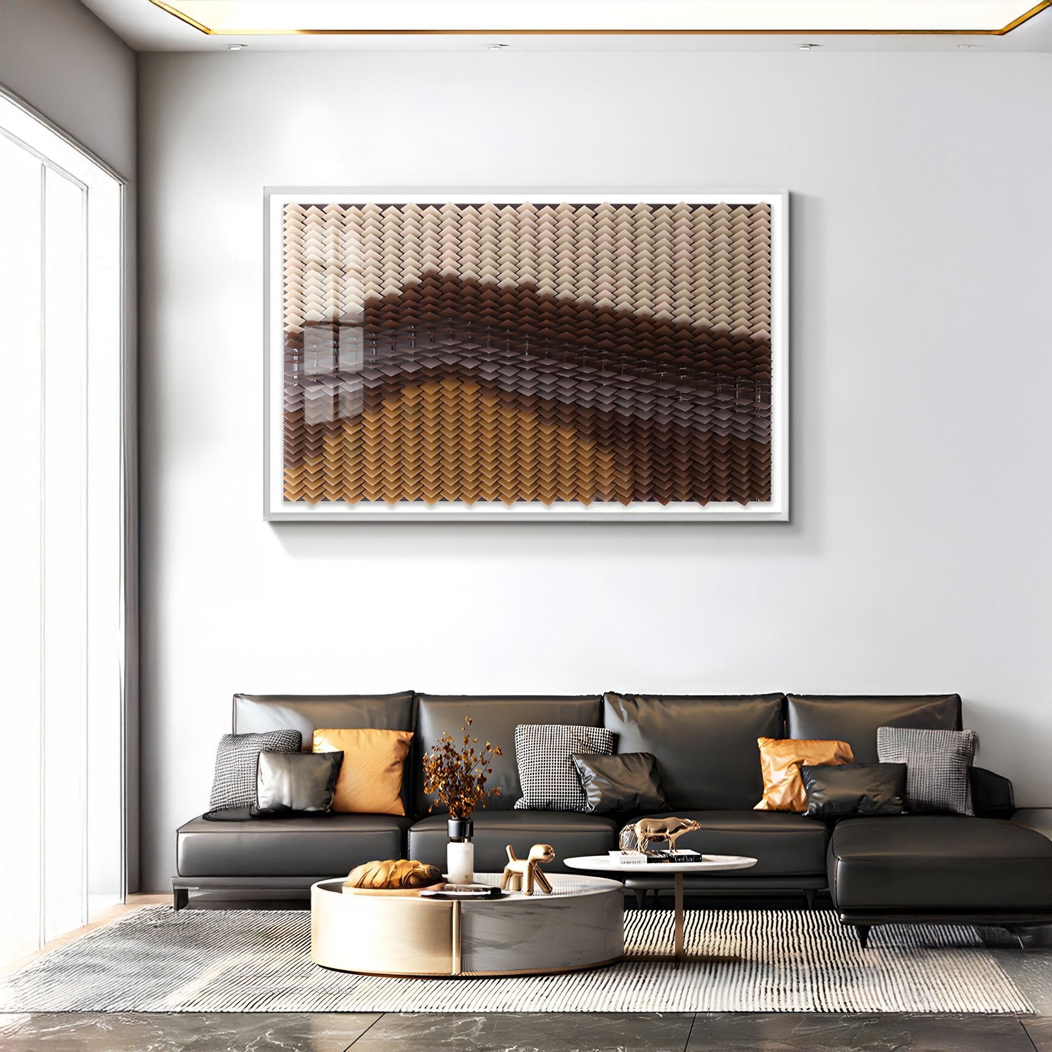 A modern living room features a black leather sofa, neutral pillows, a round coffee table, and dried flowers. Above the couch is Giant Sculptures Tessera Caramel & Walnut Gradient Acrylic 3D Wall Art, adding depth with its brown and beige tones.