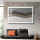A modern living room features a dark gray sofa with an orange pillow, a small round side table, and Tessera Ash Grey & Warm Sandline Acrylic 3D Wall Art by Giant Sculptures with layered gold wavy patterns above the couch.