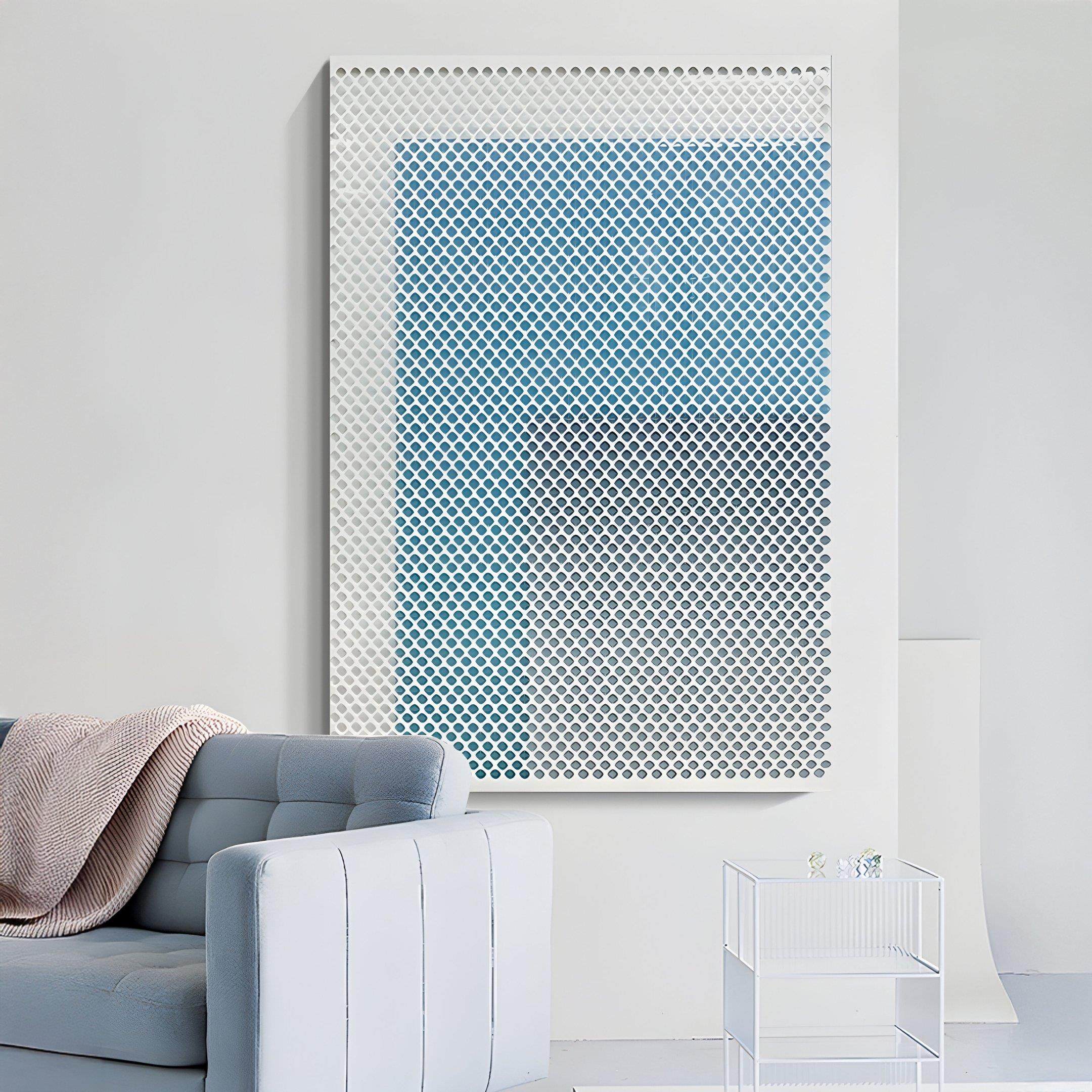 A modern living room with a light blue sofa and cozy throw features the Pixelate Sky Frost Acrylic 3D Wall Art by Giant Sculptures—a grid of white circles on a blue gradient—mounted above a small glass table on a white wall.