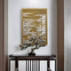 A small bonsai tree sits on a dark wooden table against a white wall, with Dynasty Dark Gold Landscape Acrylic 3D Wall Art by Giant Sculptures, featuring intricate designs, hanging above.