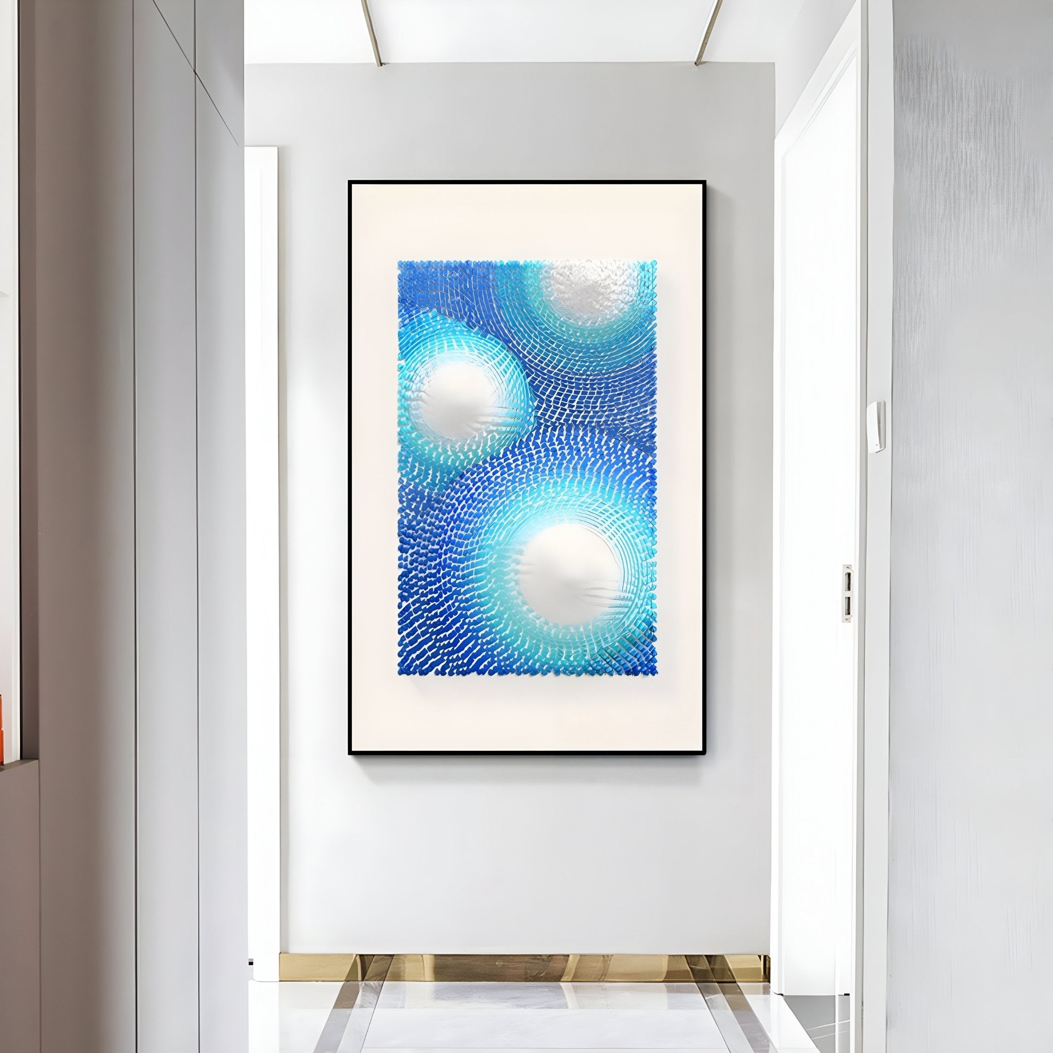 A modern hallway with white walls features a large abstract artwork in blue and white, accented by Glaciera Turquoise Sky Silver Acrylic 3D Wall Art from Giant Sculptures. A golden trim highlights the tiled floor along the walls base.