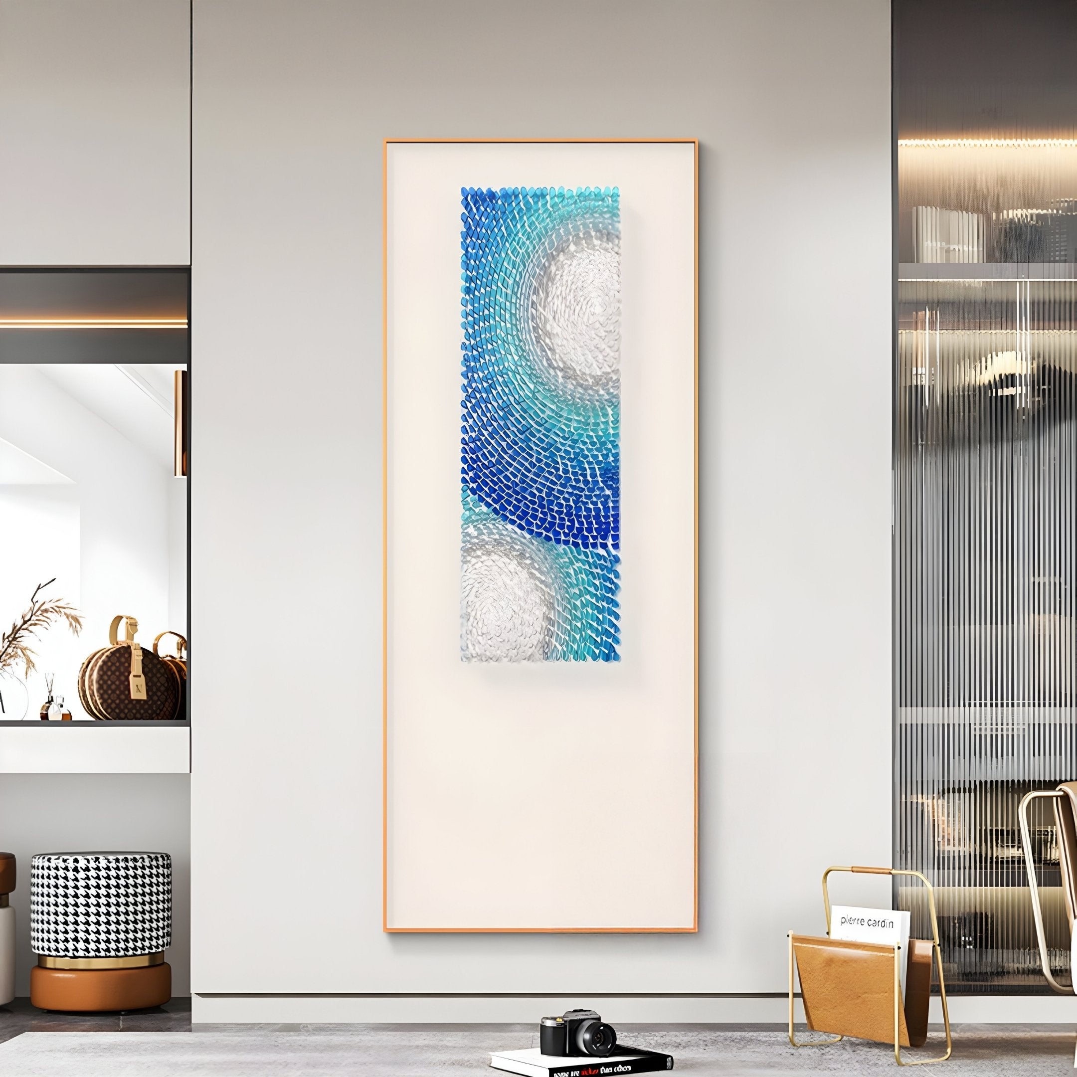 A modern living space displays Glaciera Cerulean Mint Silver Acrylic 3D Wall Art by Giant Sculptures, featuring blue, teal, and white circles on a neutral wall, alongside contemporary decor like a hat on a shelf and houndstooth stool.