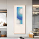 A modern living space displays Glaciera Cerulean Mint Silver Acrylic 3D Wall Art by Giant Sculptures, featuring blue, teal, and white circles on a neutral wall, alongside contemporary decor like a hat on a shelf and houndstooth stool.