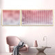 A modern living space with a pink armchair, stylish table, and the Giant Sculptures Current I Blush Coral & Snow White Acrylic 3D Wall Art, all set against a pale pink wall for chic modern decor.