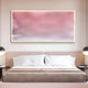 A modern bedroom features a neatly made bed with a beige headboard, two wall-mounted lamps, and Giant Sculptures’ Current II Blush Coral & Snow White Acrylic 3D Wall Art above the bed showcasing vertical red and white wavy lines.