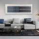 A modern living room featuring a light gray sectional, blue and gray cushions, a glass coffee table, black patterned rug, and the Flowline Slate Blue Gradient Acrylic 3D Wall Art by Giant Sculptures completes this stylish space.