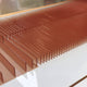 Flowline I Dual Tone Copper & Charcoal Acrylic 3D Wall Art by Giant Sculptures features rectangular panels in parallel rows on a white base, creating a striking modern geometric pattern—ideal as contemporary wall decor.