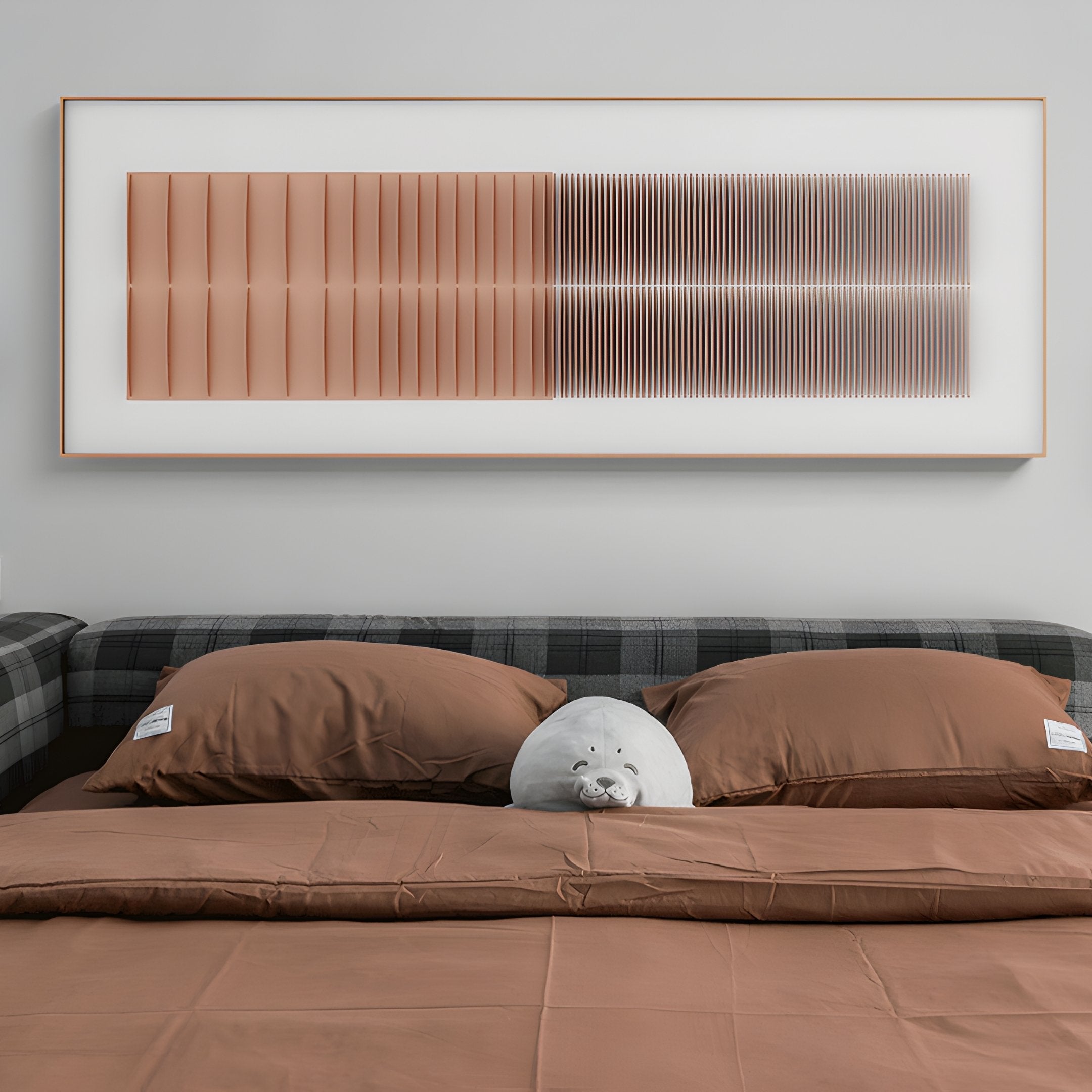 A bed with brown sheets and pillows, a plush gray seal toy in the center, and the Flowline Copper Blush Gradient Acrylic 3D Wall Art by Giant Sculptures featuring geometric brown and black lines hanging above the bed.