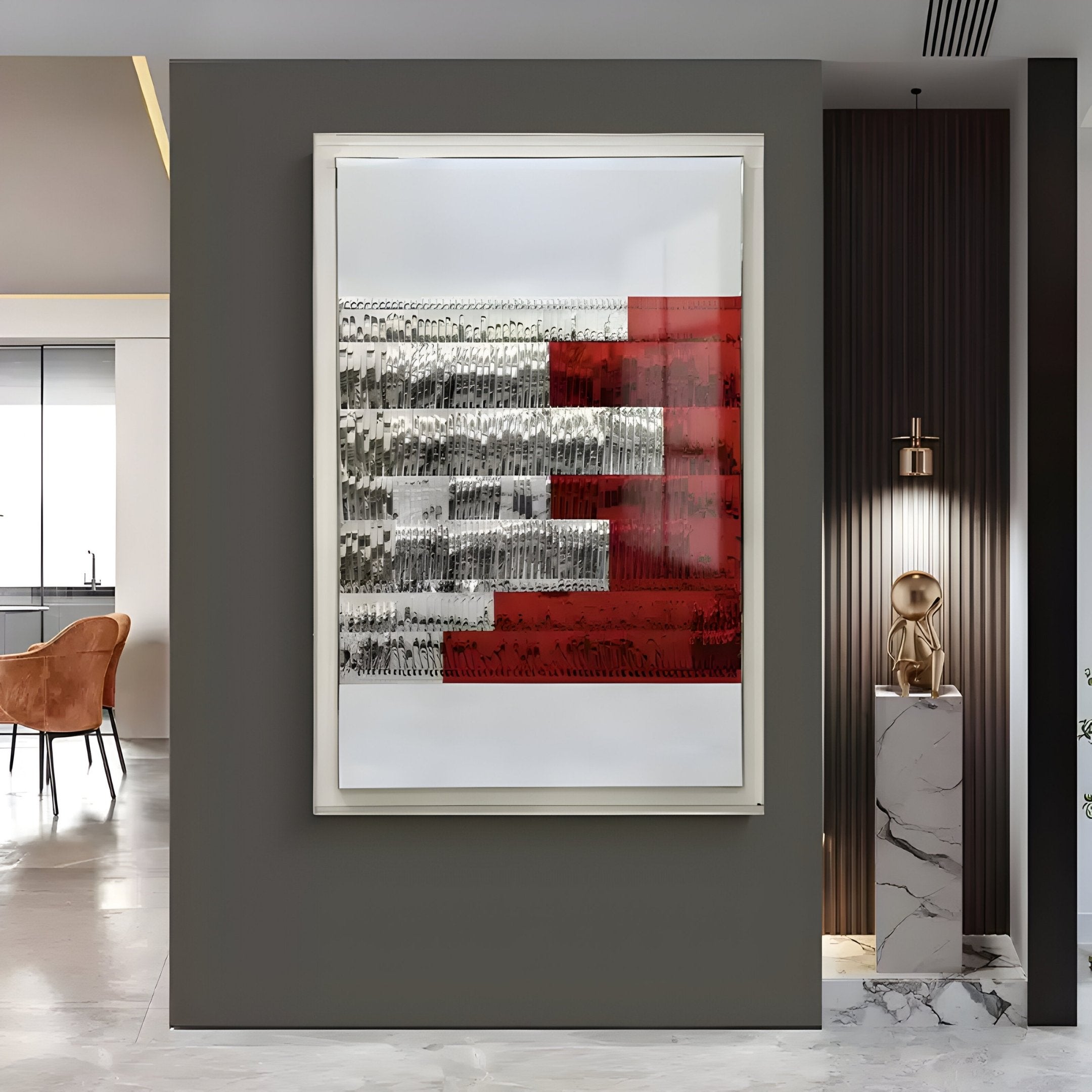 The Rhythm Crimson & Silver Layered Stripe Leather 3D Wall Art by Giant Sculptures hangs on a dark wall with marble and wood accents. A gold sculpture is displayed on a marble pedestal nearby, adding modern style to the space.