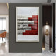 The Rhythm Crimson & Silver Layered Stripe Leather 3D Wall Art by Giant Sculptures hangs on a dark wall with marble and wood accents. A gold sculpture is displayed on a marble pedestal nearby, adding modern style to the space.