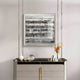 A modern sideboard with gold accents holds a glass orb, decorative animal figure, vase with dried grasses, and books. Above it hangs the Rhythm II Silver Layered Stripe Leather 3D Wall Art by Giant Sculptures on a light-toned wall.