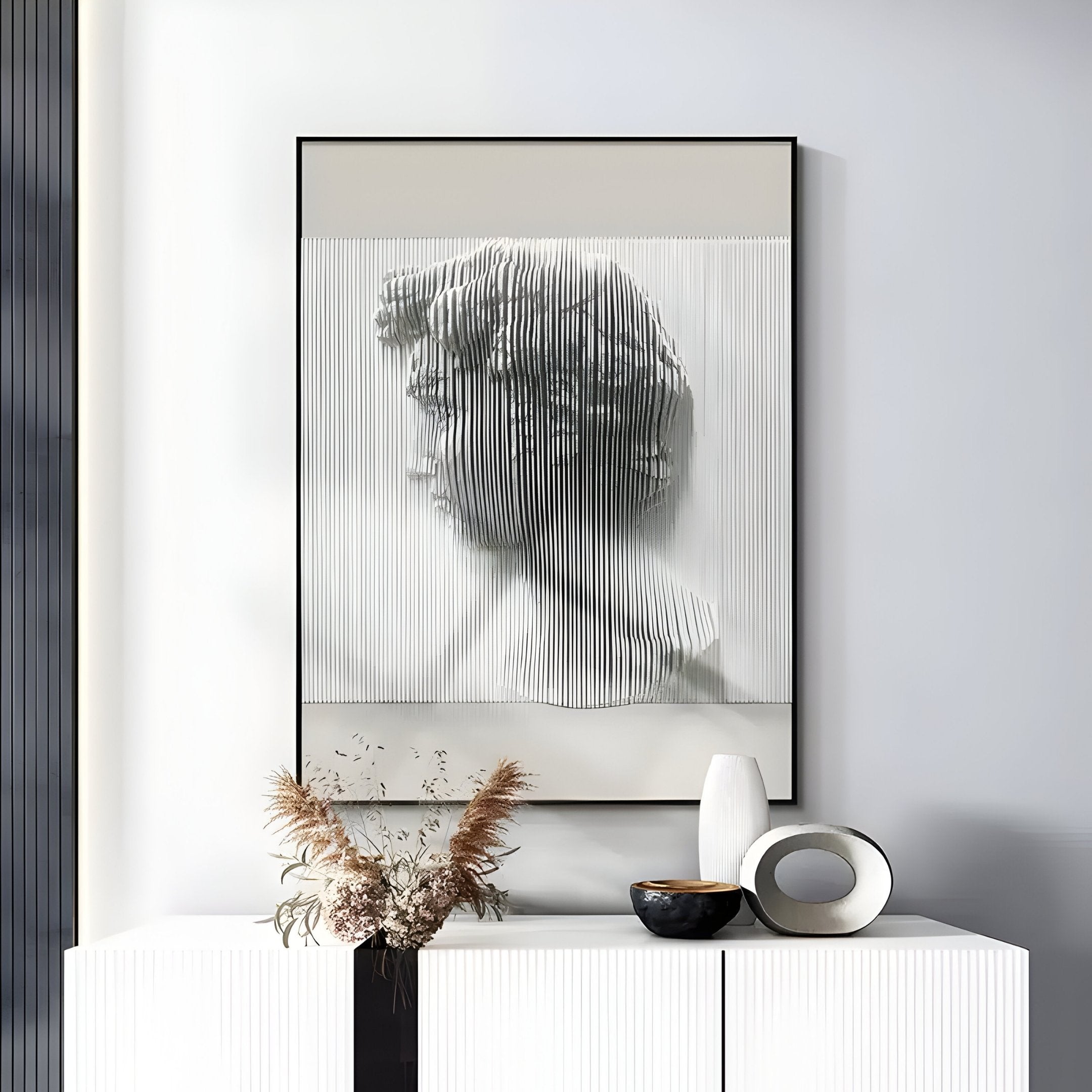The Edge Greige David Bust Leather & Acrylic 3D Wall Art by Giant Sculptures hangs above a white cabinet decorated with vases and dried plants, complementing the neutral modern interior with its unique textured design.