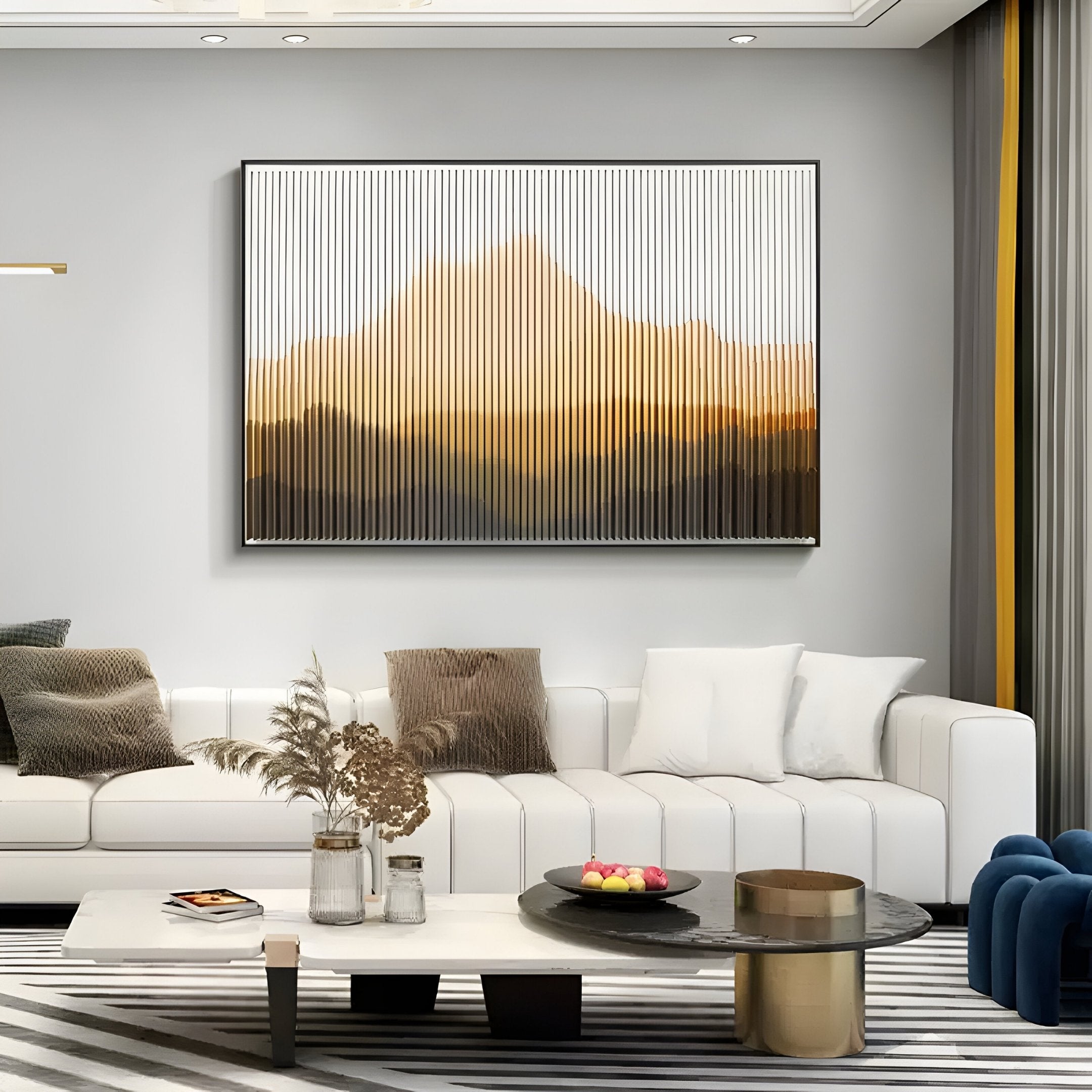 Modern living room with a white sectional sofa, striped rug, and Giant Sculptures’ Horizon Amber Ridge Mountain Acrylic 3D Wall Art in warm tones above the coffee table, which displays a bowl of fruit and dried flowers in a vase.
