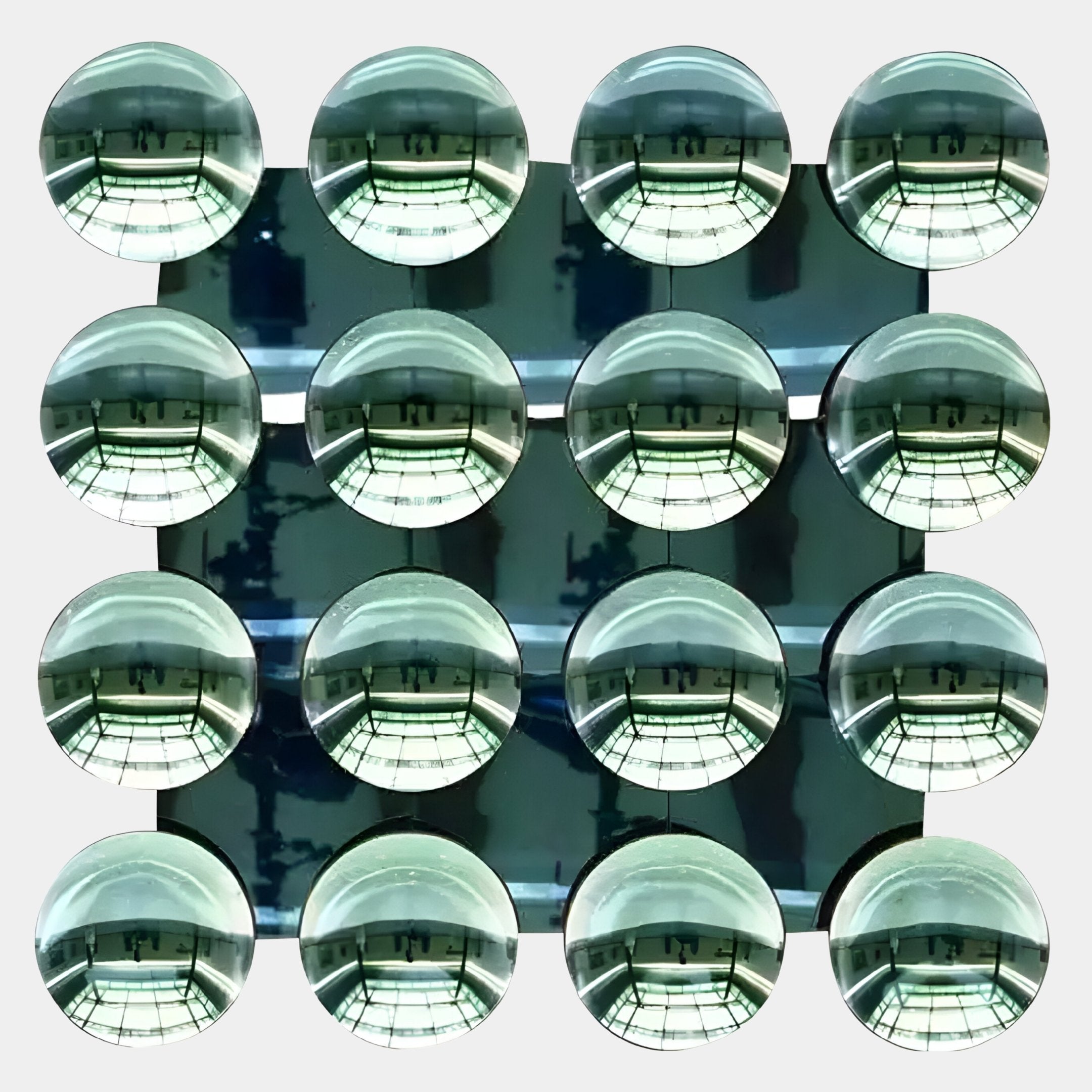 Sixteen reflective emerald green acrylic domes in a 4x4 grid by Giant Sculptures, each mirroring a bright, windowed ceiling—Dome Emerald Green Acrylic 3D Wall Art is striking modern décor for any space.
