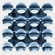 Sixteen glass-like spheres in a 4x4 grid reflect an industrial-style ceiling, creating striking contemporary 3D artwork. The Dome Ice Blue Acrylic 3D Wall Art by Giant Sculptures adds a modern touch to any white-walled space.