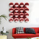 A modern living room with a red couch, black and white pillows, a decorative head sculpture, and the Giant Sculptures Dome Crimson Red Acrylic 3D Wall Art featuring 16 shiny crimson red spheres reflecting the room.