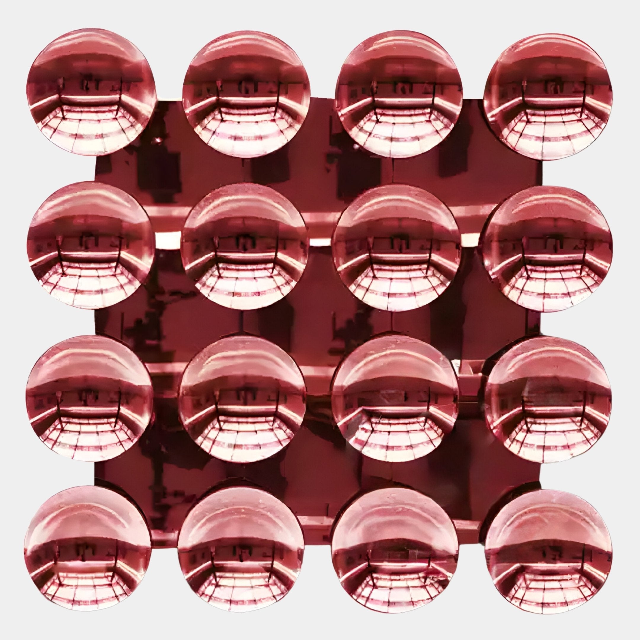 Sixteen crimson red acrylic domes by Giant Sculptures form a four-by-four grid, creating a 3D wall art effect. Symmetrical reflections and geometric patterns enhance the modern “Dome Crimson Red Acrylic 3D Wall Art” against a white background.