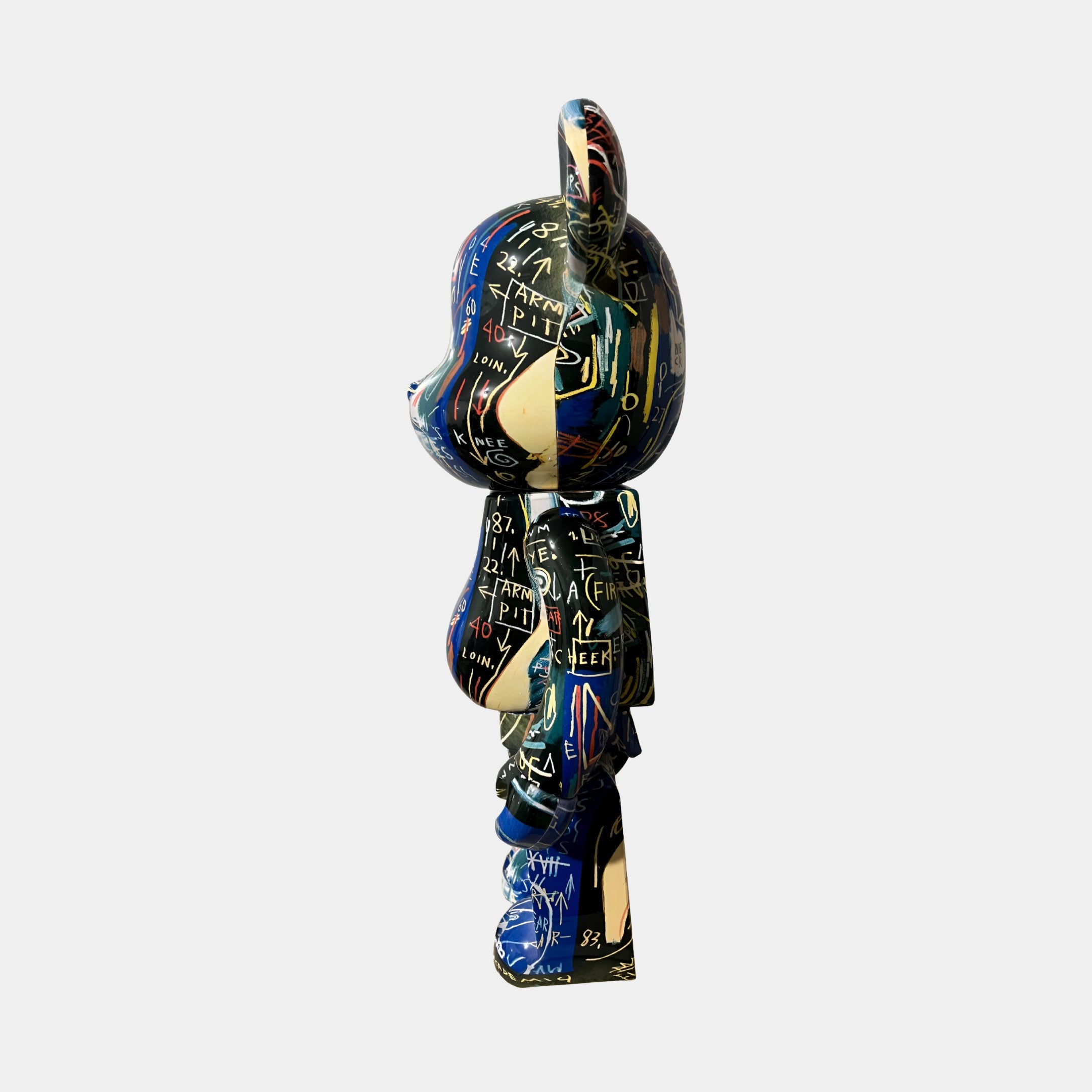 A side view of the Giant Sculptures Abstract Graffiti Bear Sculpture - 70cm, a limited edition resin piece with graffiti-style designs and abstract patterns on a dark background, displayed against a plain white backdrop.