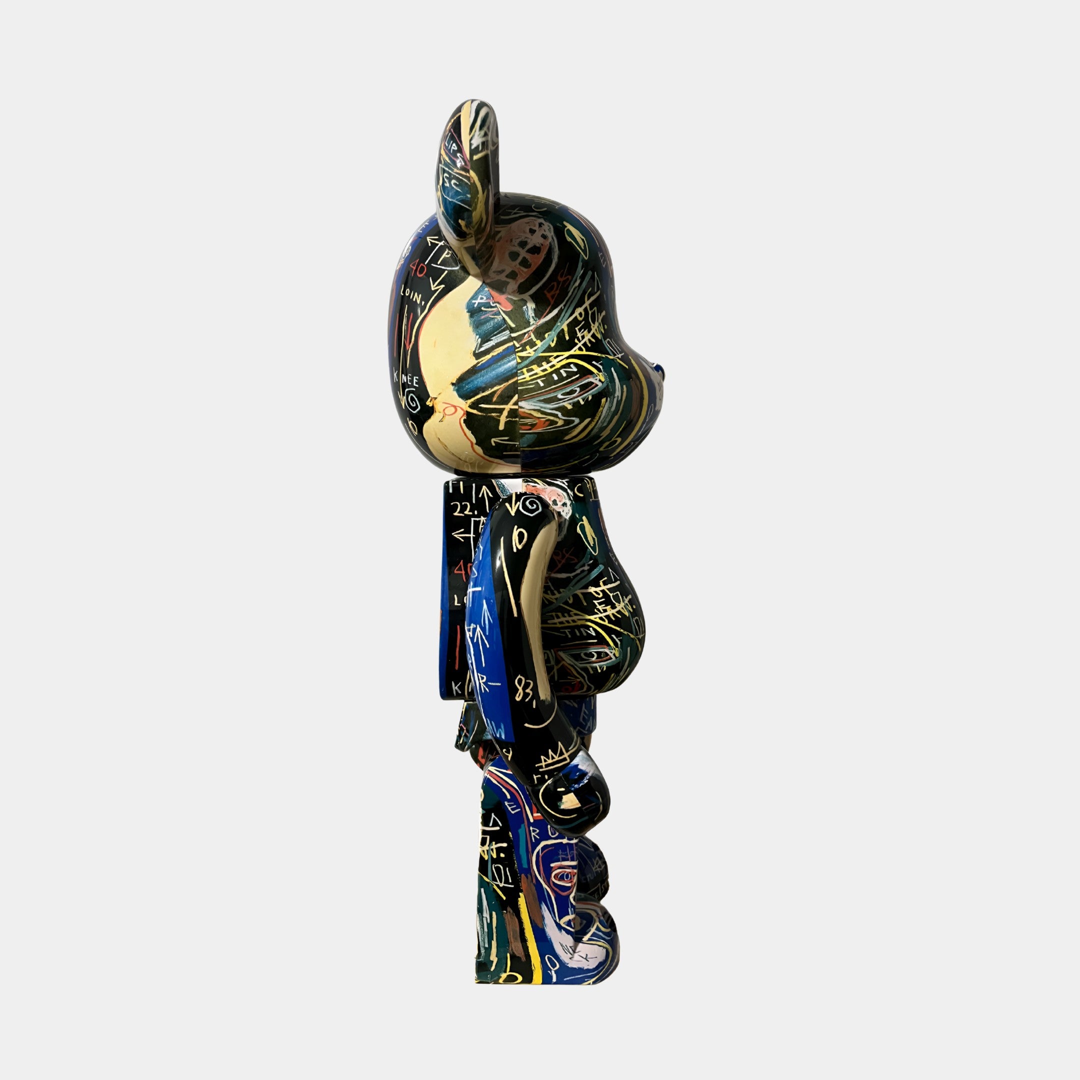 A side view of the Abstract Graffiti Bear Sculpture - 70cm by Giant Sculptures, featuring a stylized bear shape with bold yellow, green, blue, and black abstract designs, set against a plain gray background.