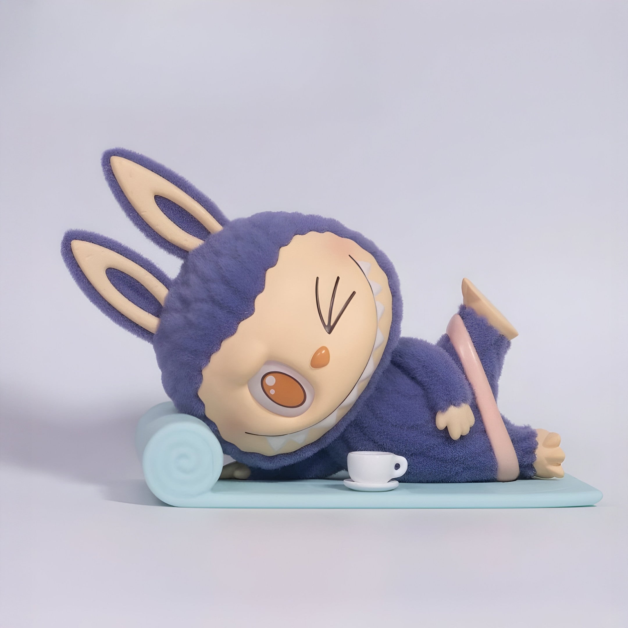 The Lazy Yoga Americano Labubu Sculpture - 100cm by Giant Sculptures features a fuzzy purple bunny-costumed figure lying on a blue mat with closed eyes, mouth open, and a tiny white teacup—an adorable art piece for any space.