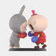Two Spooky Buddies—one in a gray bunny suit with red gloves, the other in a red outfit with skull mask, pink hat, and blue gloves—face off forehead to forehead on a black base in this 100cm Labubu Sculpture from Giant Sculptures.