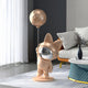 The Rose Gold Astronaut Bunny Moon Balloon Sculpture from Giant Sculptures adds charm to a modern living room, while rose gold accents, round coffee table, and sheer-curtained large window create a cozy, stylish atmosphere.