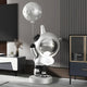 The Cosmic Chrome Astronaut DJ Moon Balloon Sculpture by Giant Sculptures stands 100cm tall, adding futuristic charm with its reflective helmet and black-and-white suit. It enhances the rooms modern decor with its striking design, perfectly complemented by nearby furniture.