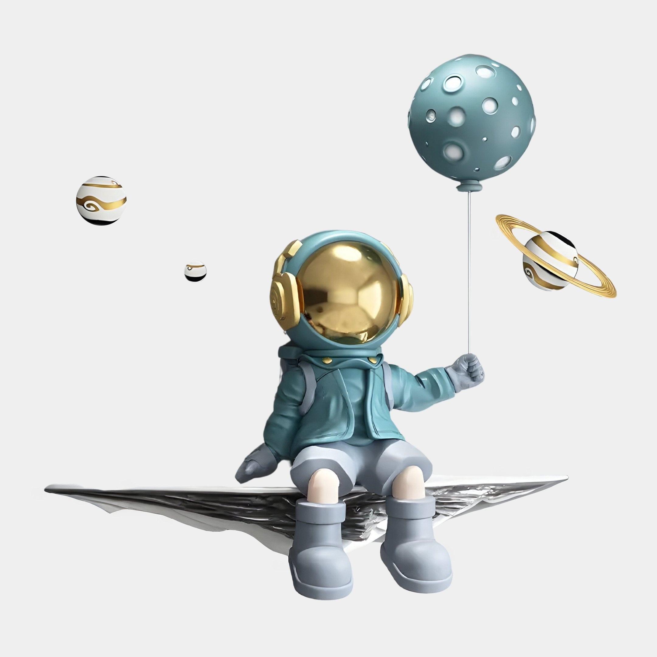 The Blue 3D Dreamer Balloon Astronaut Wall Art by Giant Sculptures features a resin figure with a shiny gold helmet on a moon-shaped platform, complemented by a blue outfit and surrounded by ringed planets, creating a whimsical cosmic scene.