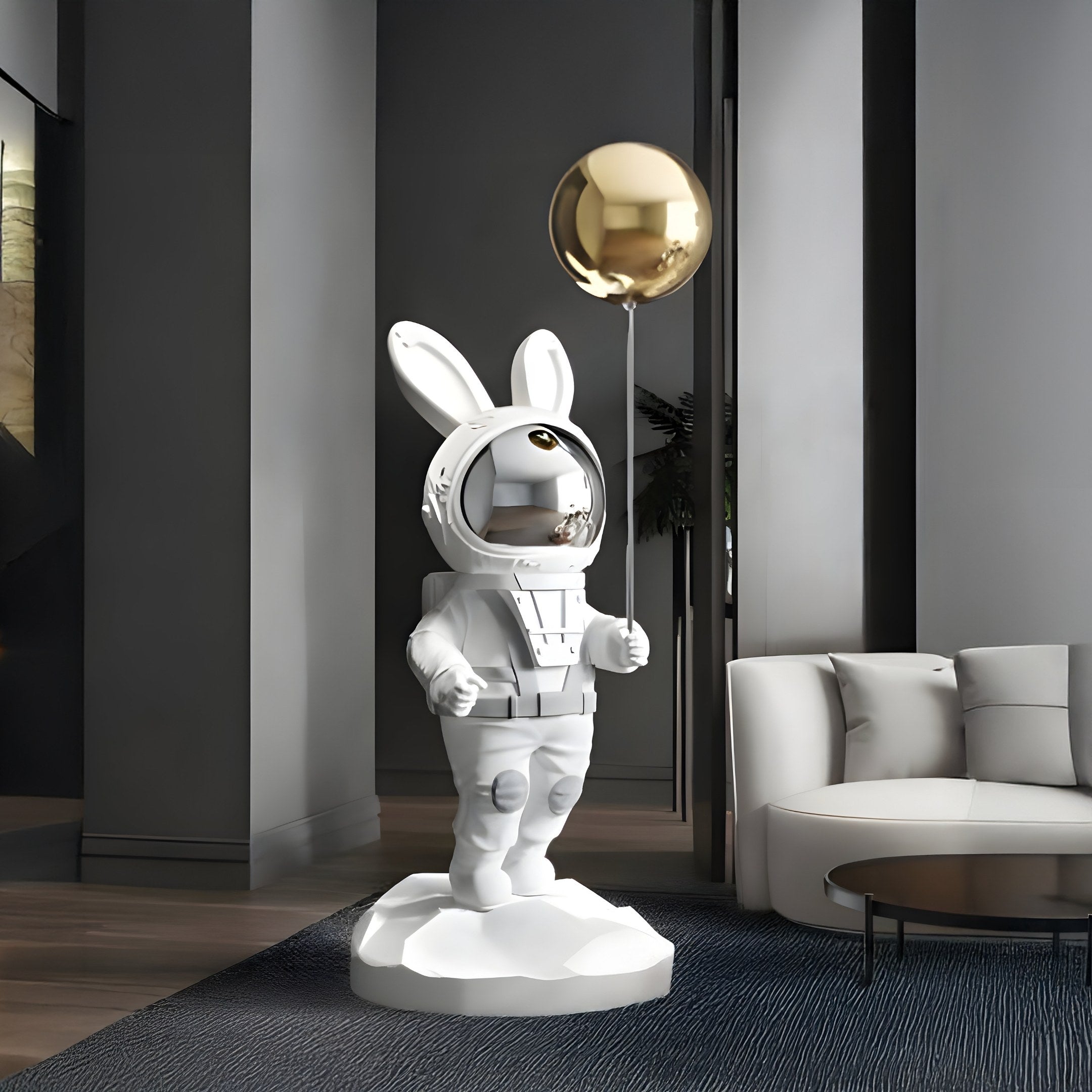 In a modern interior, the minimalistic decor features Giant Sculptures White Astronaut Floppy Bunny Balloon Sculpture (106cm), enhancing the stylish atmosphere with gray walls, a white sofa, and a black coffee table.