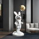 In a modern interior, the minimalistic decor features Giant Sculptures White Astronaut Floppy Bunny Balloon Sculpture (106cm), enhancing the stylish atmosphere with gray walls, a white sofa, and a black coffee table.