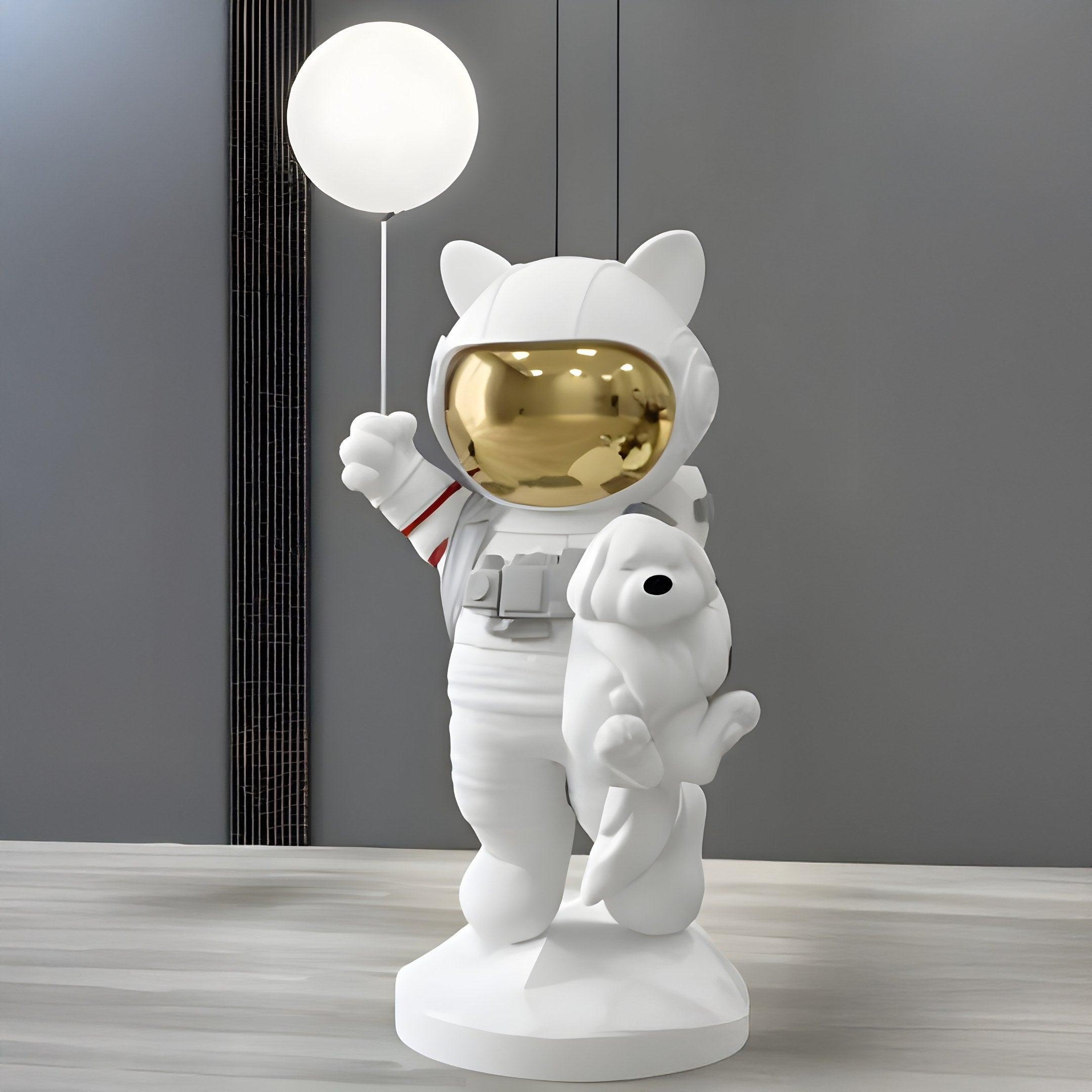 A Nova White Astronaut Kitty Pup Glow Balloon Sculpture by Giant Sculptures, featuring a bear in an astronaut suit with a glowing balloon and shiny gold visor, cradles an animal under one arm. The minimalist scene includes gray walls and vertical lines, enhancing its whimsical charm.