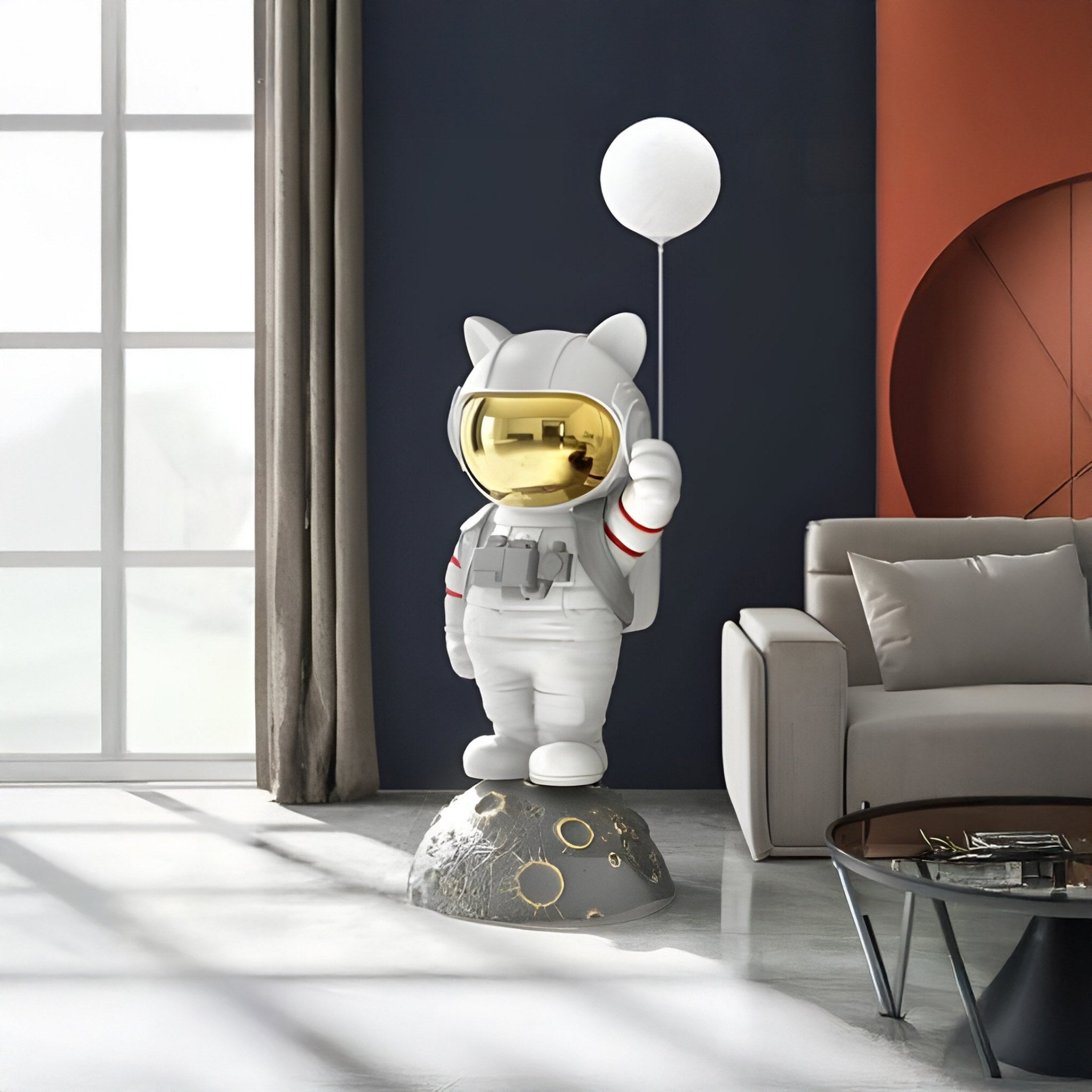 The Nova White Astronaut Kitty Glow Balloon Sculpture by Giant Sculptures, featuring cat ears and a gold visor, stands on a moon-like base adding interstellar fun to a modern living room with its 120cm presence.