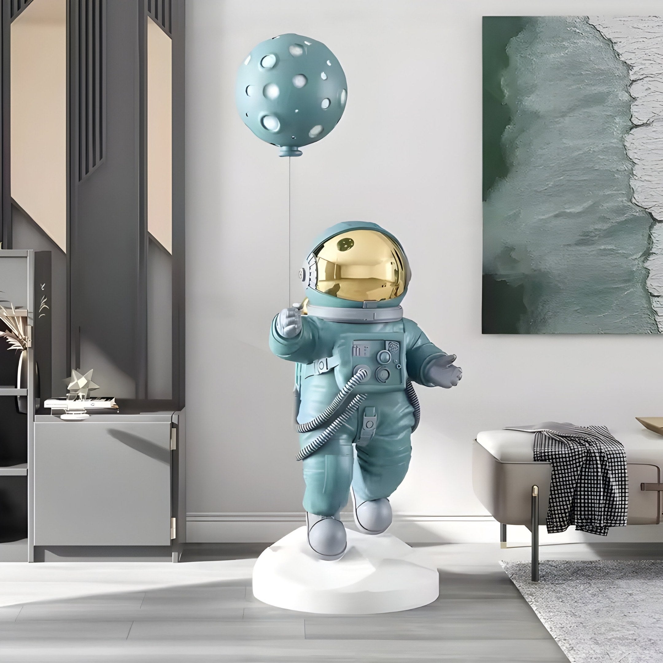 A Galactic Blue Astronaut Ranger Balloon Sculpture by Giant Sculptures stands in a modern living room with abstract wall art and contemporary furniture, wearing a blue suit with a reflective helmet and holding a textured balloon that echoes an outer space theme.