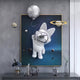 The Chrome 3D Astronaut Bunny Balloon Starry Wall Art by Giant Sculptures features a chrome-helmeted bunny floating in space. Mini planets and a moon emerge from the piece, complemented by a table below with a geometric sculpture, flowers, and clock, creating an elegant modern space-themed display.