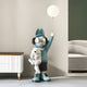 A 130cm Blue Astronaut Bunny Pup Glow Balloon Sculpture by Giant Sculptures depicts a whimsical child in blue with bunny ear hat and headphones, clutching a polar bear plush and glow balloon, enhancing any space-themed décor near modern furniture indoors.