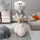 Giant Sculptures Soft Grey Cloudsit Glider Bear Sculpture – 150cm resin bear in soft grey jacket seated on a paper glider above layered cloud base, shown in a modern living room.