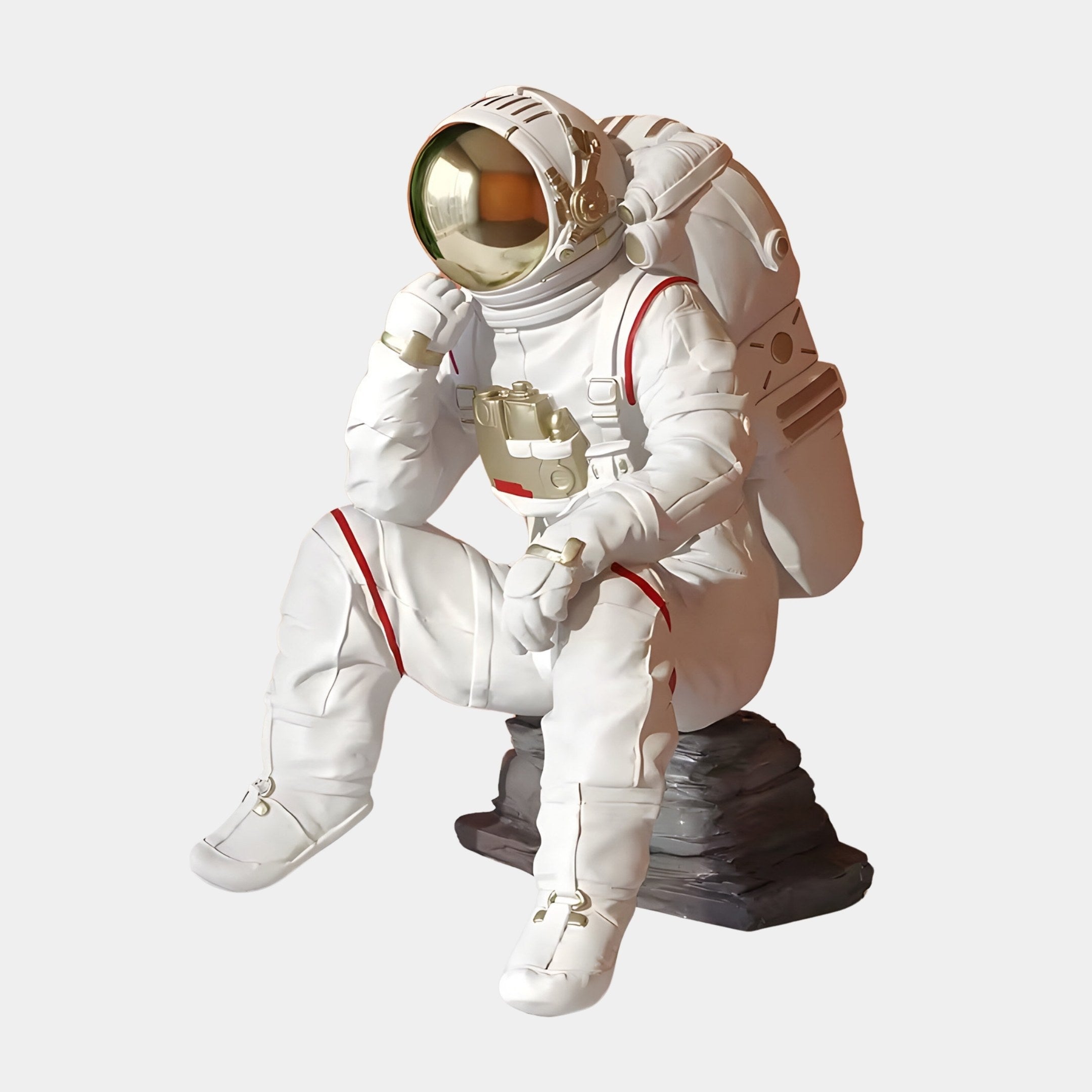 The Nova White Astronaut Thinker Figure (43cm) from Giant Sculptures sits on a rock with a reflective gold visor, red stripes, and gray boots in an interstellar theme.