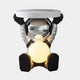 The Lunar Silver Astronaut Glow Side Table Figure (50cm) by Giant Sculptures features a seated astronaut with a shiny lunar silver helmet, black gloves and boots, holding a round tabletop above and a glowing orb on its lap.