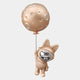 A rose gold astronaut bunny with a shiny faceplate holds a cratered moon balloon, floating upward—a whimsical cosmic scene by Giant Sculptures. The 58cm 3D wall art features a plain light gray background, perfect for unique decor.