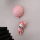 The Pink Astronaut Bunny Balloon 3D Wall Art (58cm) by Giant Sculptures, featuring a shiny pink bunny-eared astronaut, adds playful, futuristic charm to a plain wall near a black marble staircase.