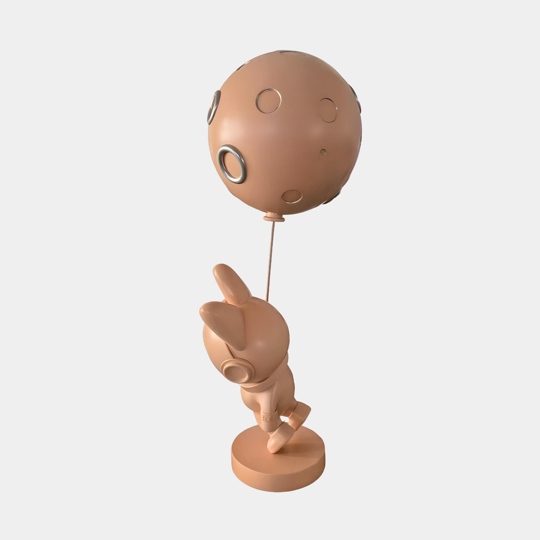 Side view of the Giant Sculptures Rose Gold Astronaut Bunny Moon Balloon Sculpture at 60cm, bunny in helmet reaching for a cratered moon balloon on a plain background.