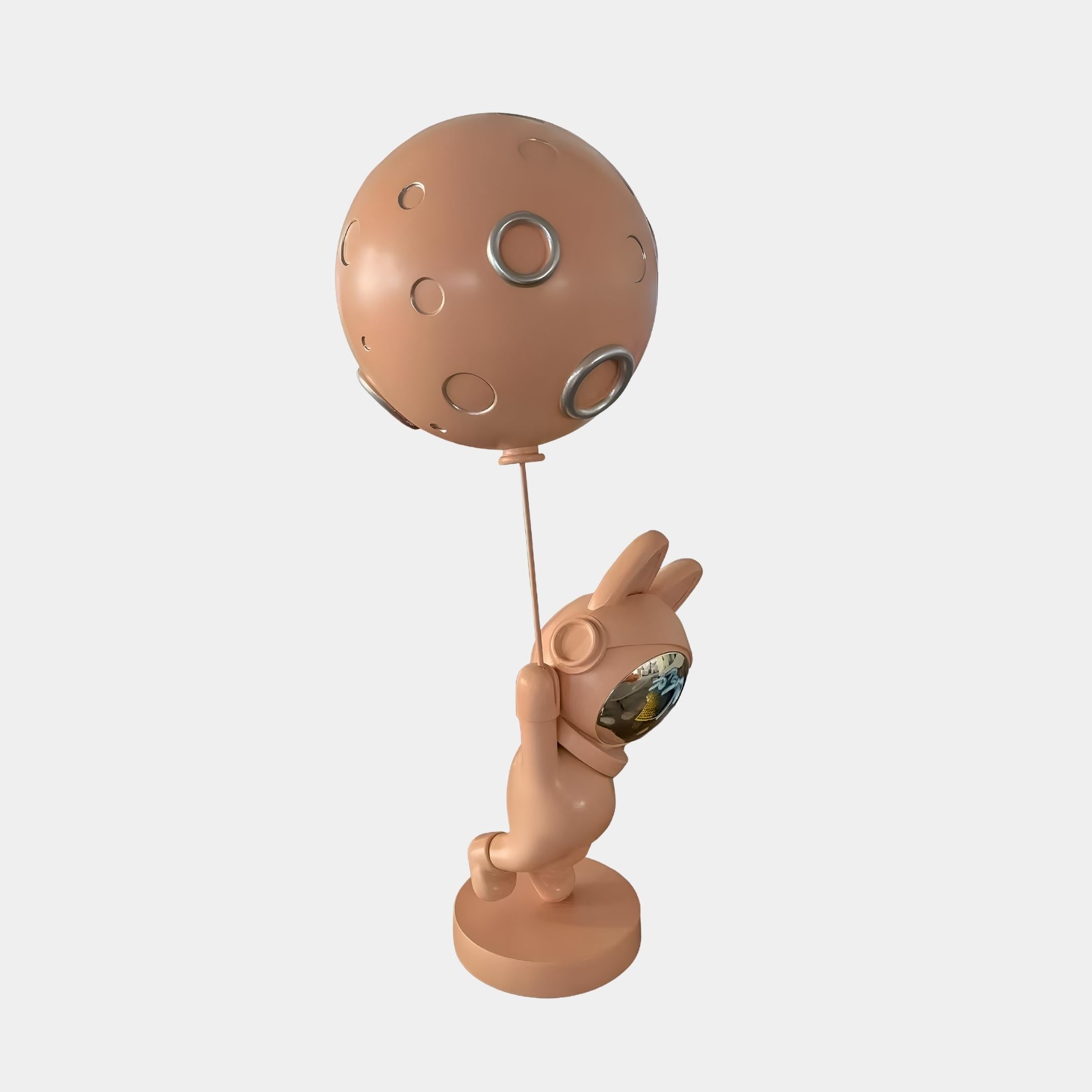 Rose Gold Astronaut Bunny Moon Balloon Sculpture by Giant Sculptures, 60cm rose-gold bunny in space helmet holding a cratered moon balloon, on plain background.