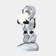 The Nova White Astronaut Glow Hover Sculpture by Giant Sculptures features a stylized astronaut in a reflective white suit with metallic visor, black gloves, and boots. Standing on a rock-like base while holding a glowing orb, it adds modern décor to any space against a plain gray background.