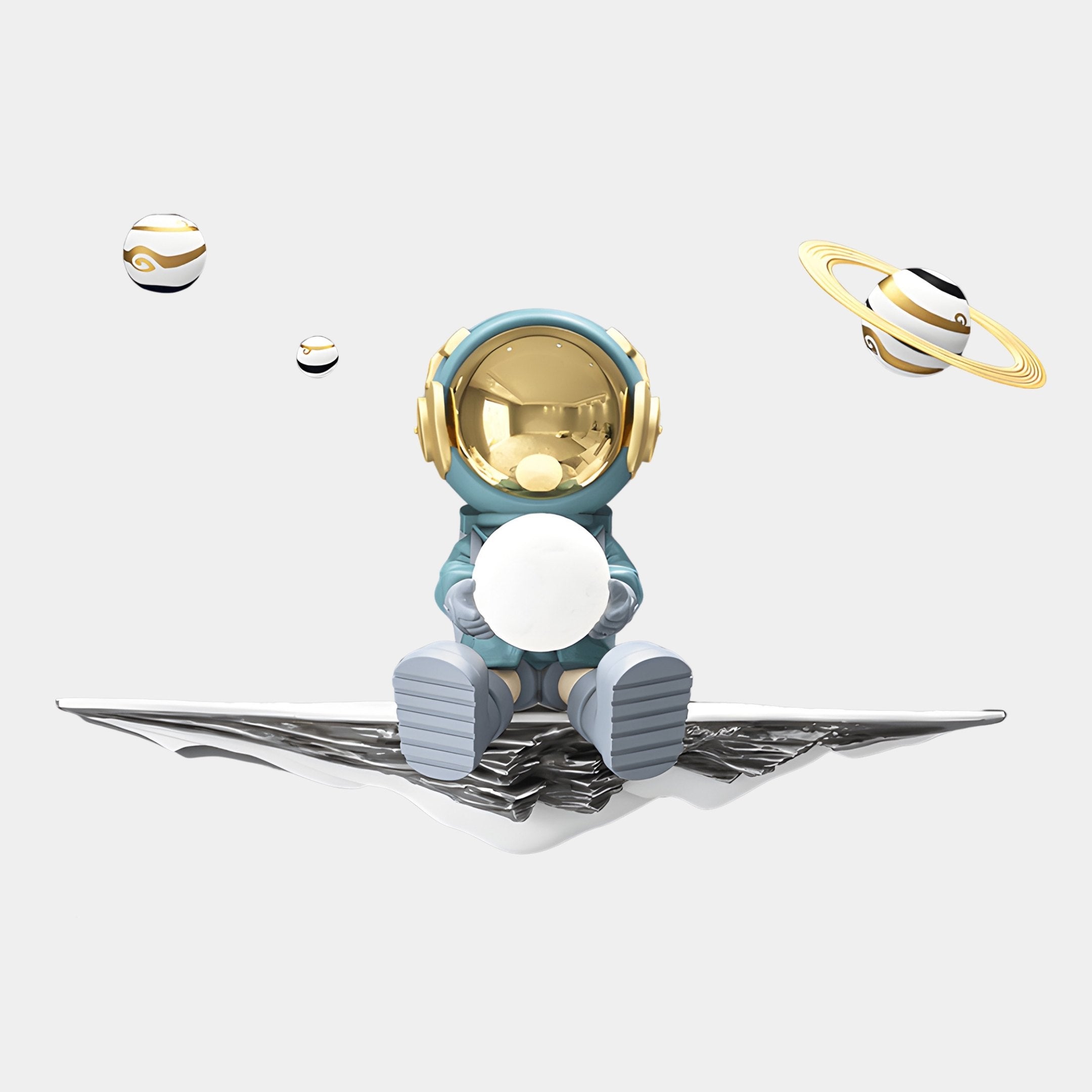 The Giant Sculptures Blue 3D Dreamer Glow Astronaut Wall Art features a whimsical resin astronaut with a gold helmet and blue suit on a metallic surface, holding a glowing orb amid floating, golden-ringed planets on a white background, radiating cosmic charm.