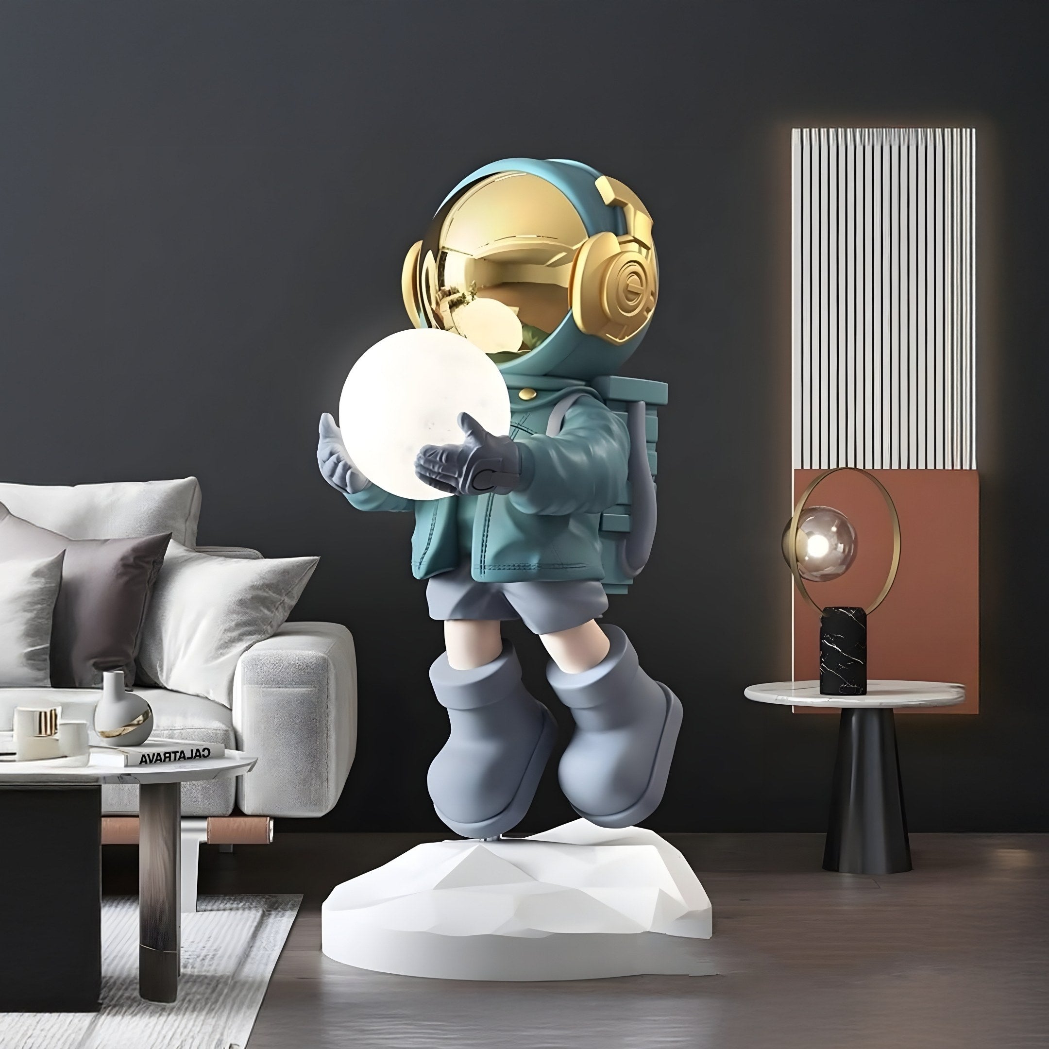 The Galactic Blue Astronaut Glow Hover Sculpture by Giant Sculptures, standing at 80cm, features a metallic gold helmet and teal outfit cradling a glowing orb. It hovers above a geometric platform, adding cosmic charm to a modern living room with a gray couch and minimalist decor.