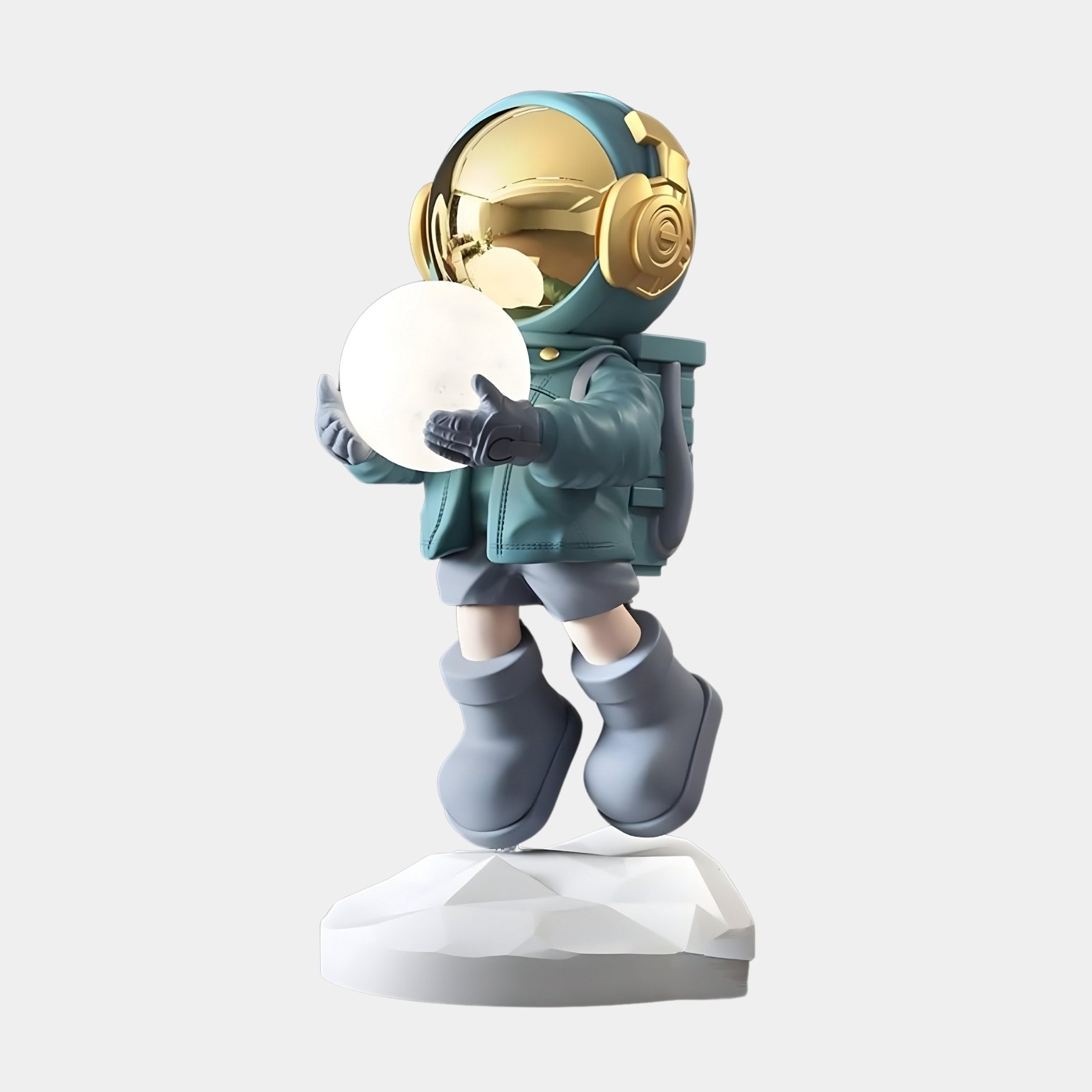 The Galactic Blue Astronaut Glow Hover Sculpture - 80cm by Giant Sculptures features a stylized figure with a reflective golden helmet and teal spacesuit holding a glowing orb, standing on an uneven white platform with large boots, creating a cosmic glow against the plain background.