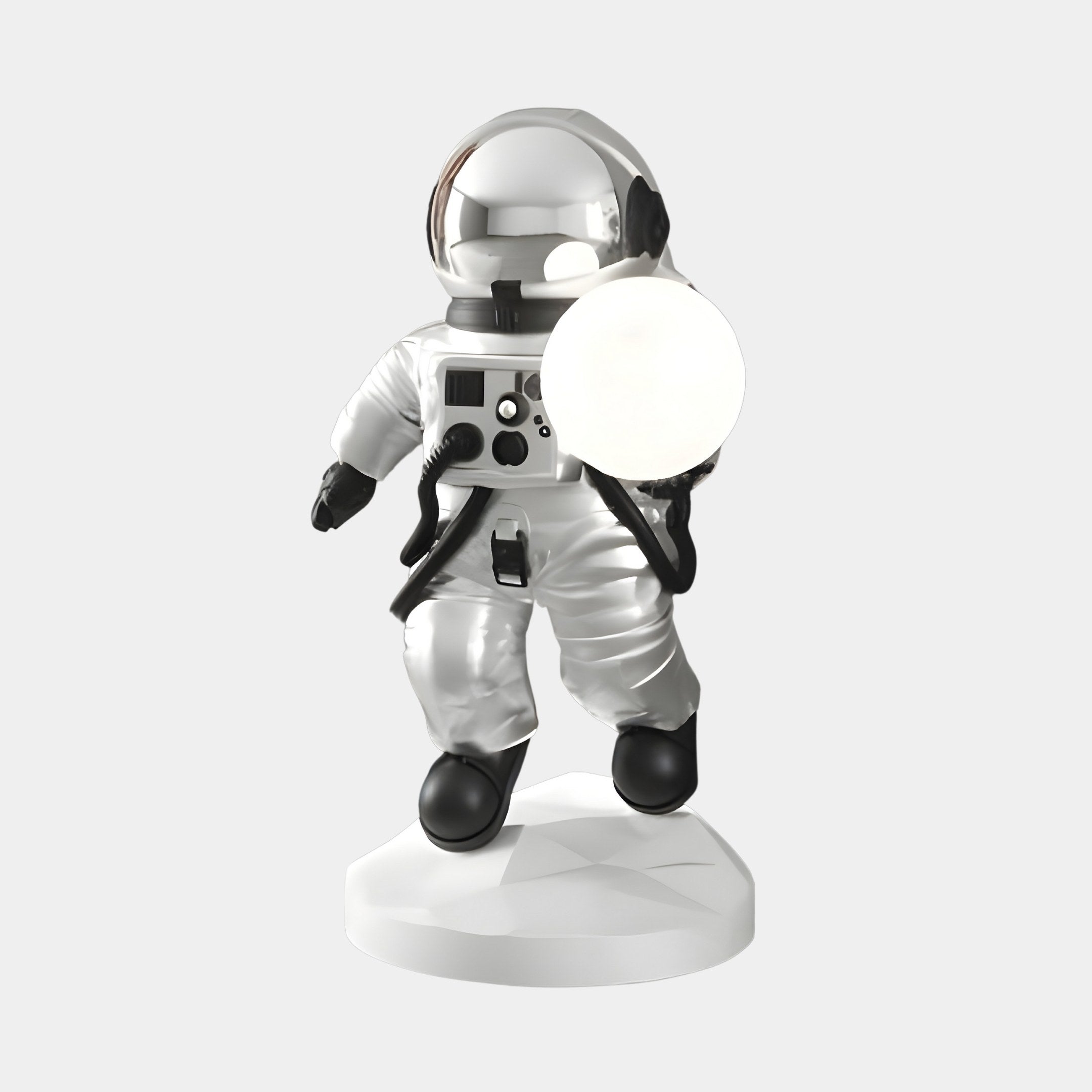 The 80cm Lunar Silver Astronaut Ranger Glow Orb Sculpture by Giant Sculptures features a glowing white disc and stands confidently on a sleek white base against a light gray backdrop, with classic spacesuit, reflective helmet, and black boots for captivating futuristic décor.